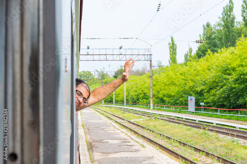 man looks out of the window of the train