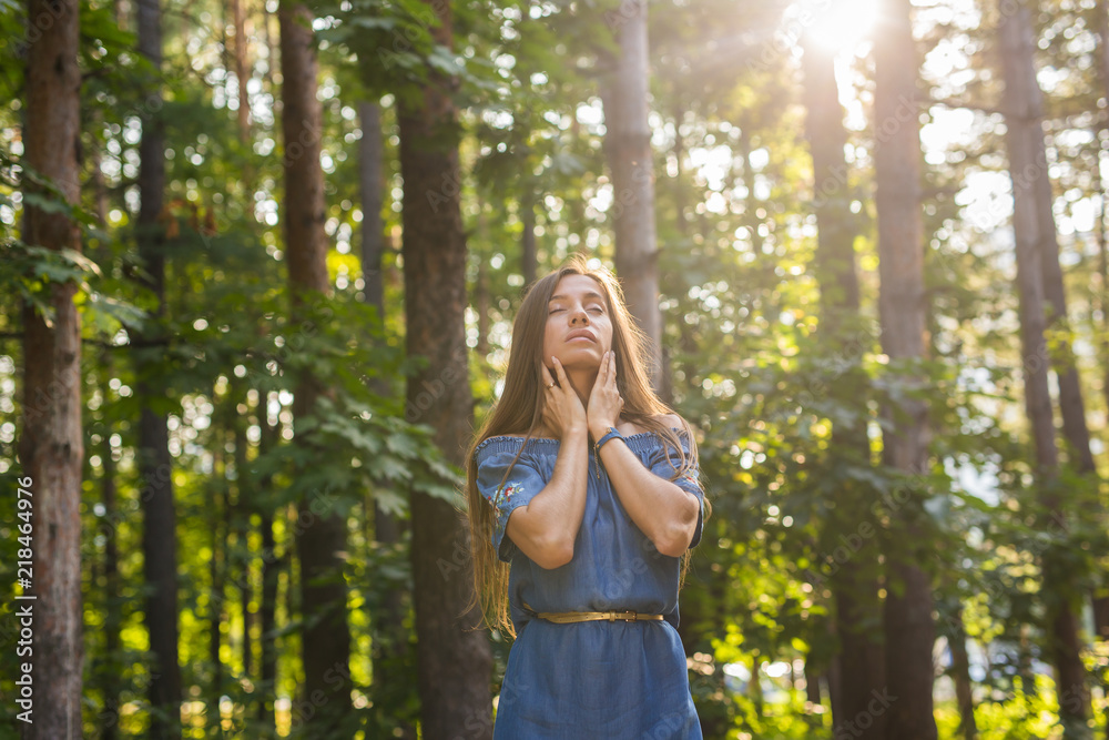 Nature, summer and people concept - Young woman posing in green forest Nature, summer and people concept - Young woman posing in green forest