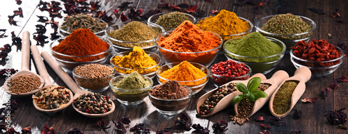 Photo Variety of spices and herbs on kitchen table