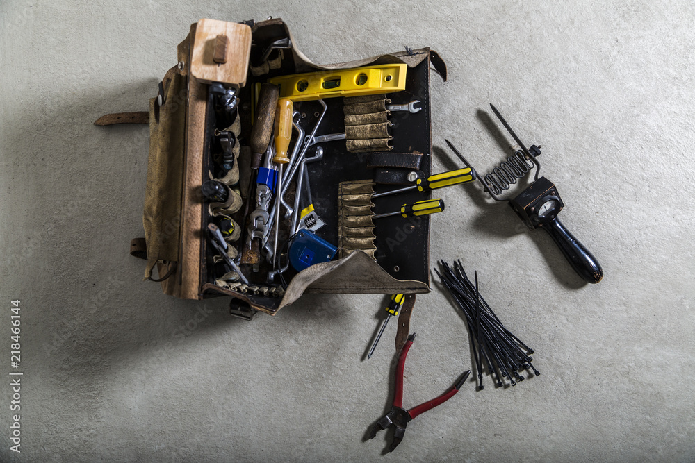 Box with electrician tools on leather background
