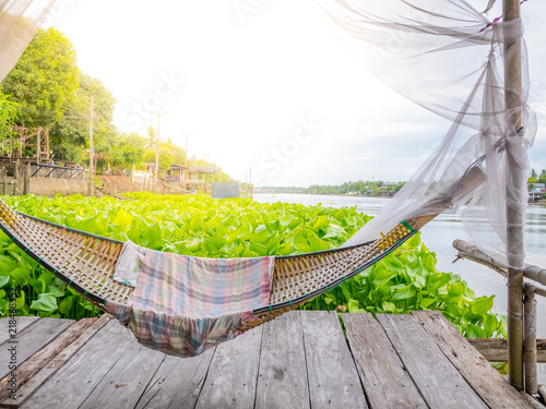 Traditonal thai cuture cradle hanging on the raft at the river water hyacinth.Relax time in the holiday sunnyday. photo