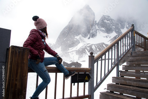 Tourist woman standing and looking at beautiful view of Yulong snow mountain or Jade dragon snow mountain in Lijiang city, China