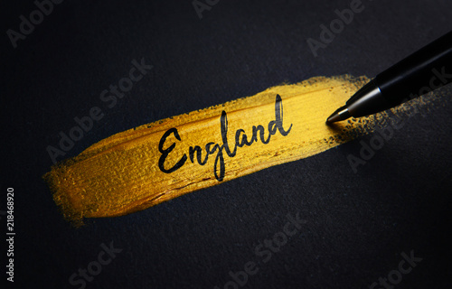 England Handwriting Text on Golden Paint Brush Stroke