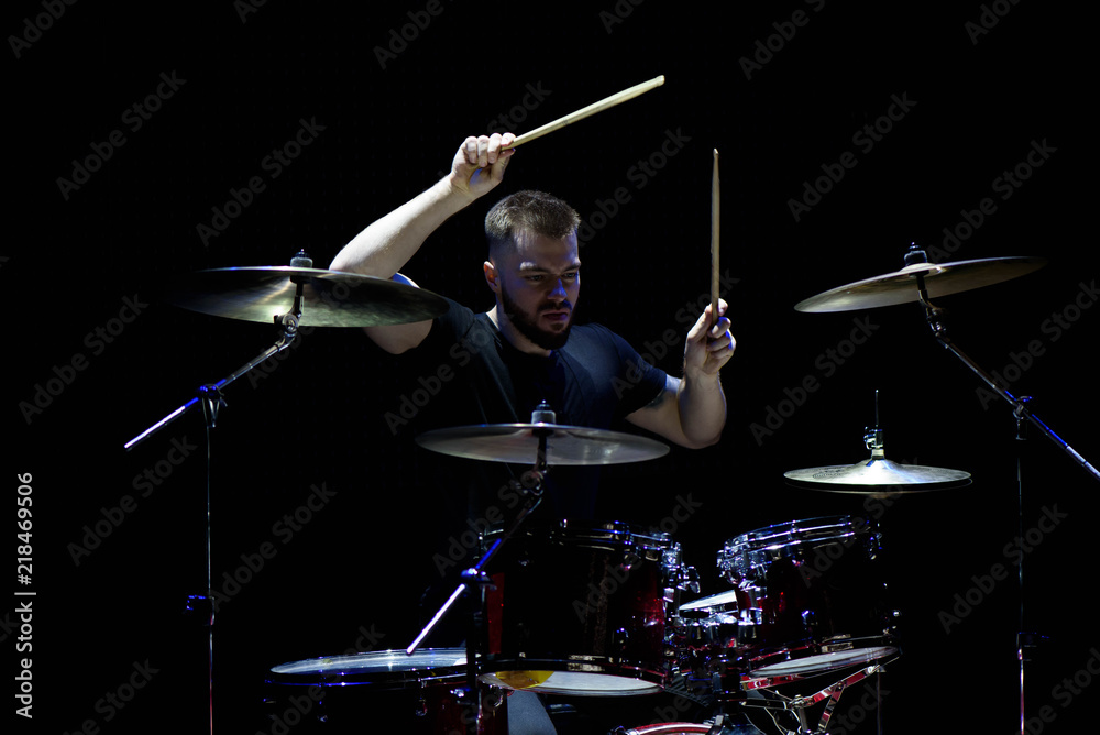 Fototapeta premium music, people, musical instruments and entertainment concept - male musician with drumsticks playing drums and cymbals at concert or studio