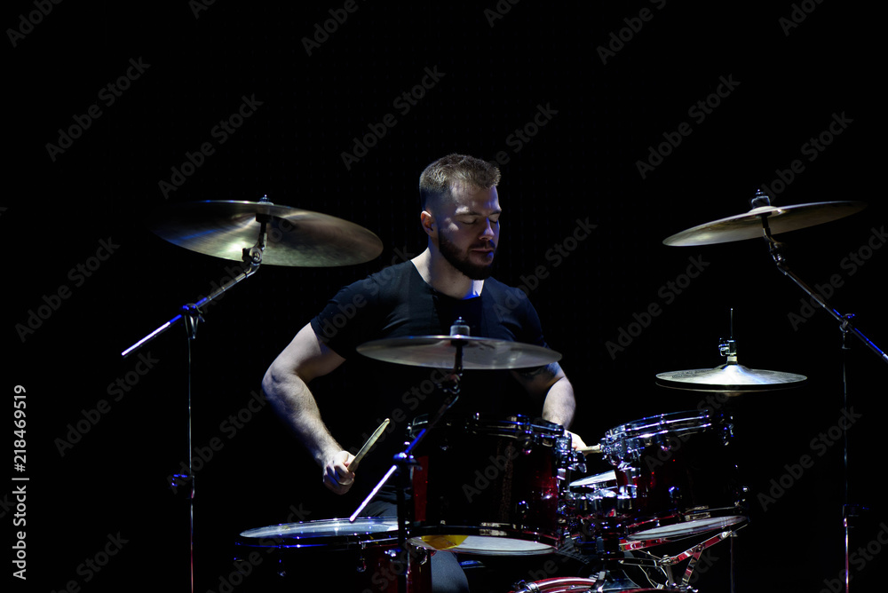 Fototapeta premium music, people, musical instruments and entertainment concept - male musician with drumsticks playing drums and cymbals at concert or studio