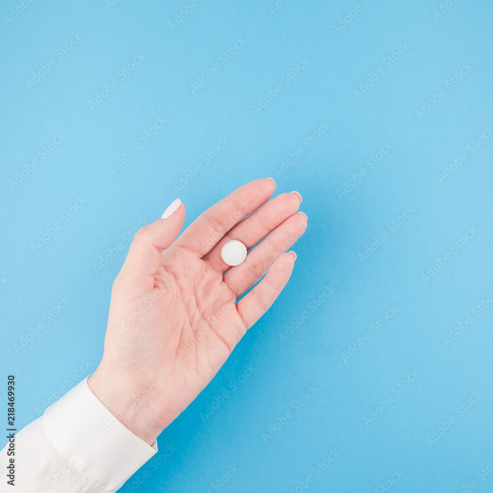 Naklejka premium Female hand holding a white pill