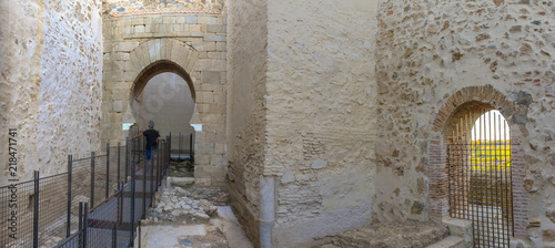 Visitor walking towards shoehorse arch of Alcazaba of Badajoz, Spain photo