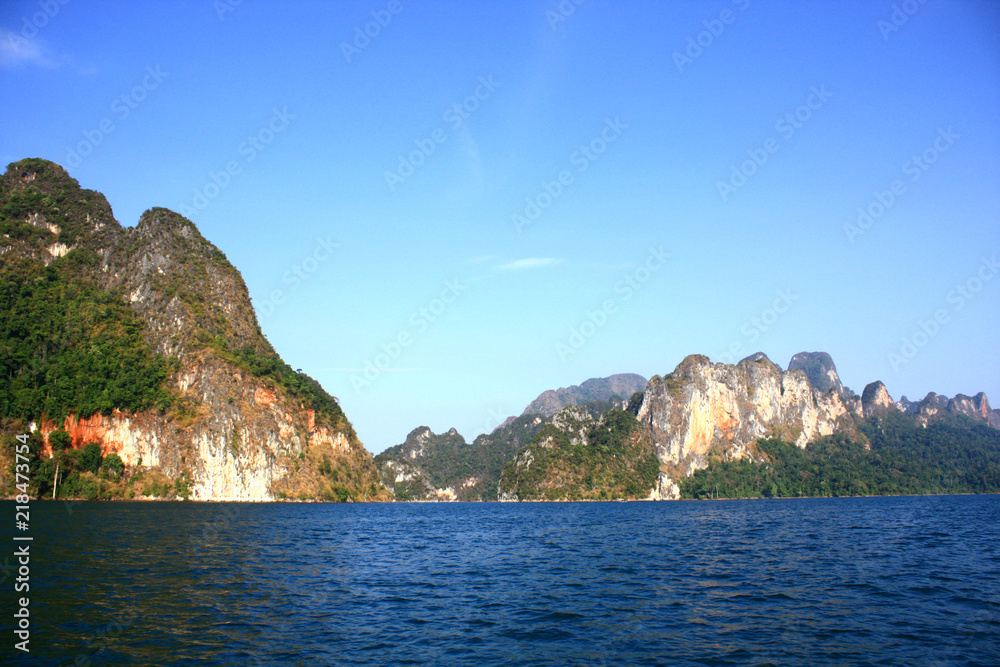 Landscape of Dam with Mountain and river near forest hills in Blue sky at Ratchaprapha Dam at Khao Sok National Park, Surat Thani Province, Thailand.
