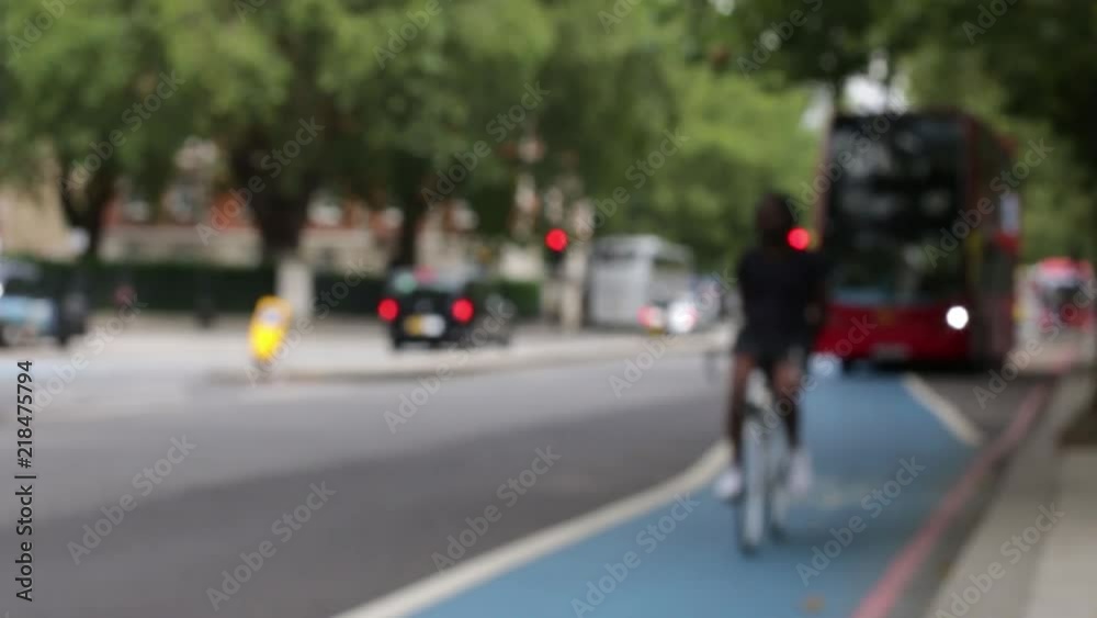 Blurred View of Traffic on a London Road With a Red Bus, Cars and a Cyclist on a Cycle Superhighway Passing Camera