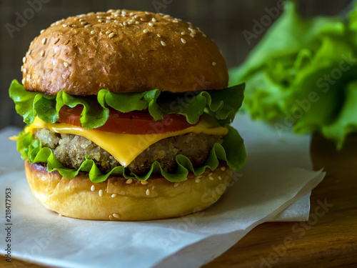 Hamburger is big. Cheeseburger's on the table. The unhealthy food. The concept of healthy eating. photo
