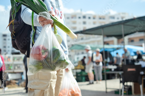 Close up on person buyer hold groceries in bags. Buy sell vegetables. Healthy wellbeing lifestyle background