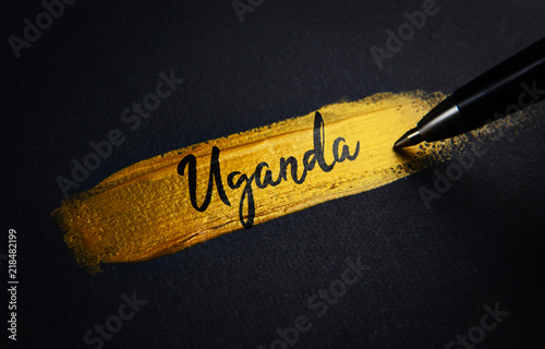 Uganda Handwriting Text on Golden Paint Brush Stroke