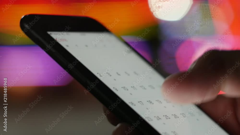 User looking at calendar dates on a smartphone - schedule for summer holiday vacation, business meatings, appointments, new initiatives concept