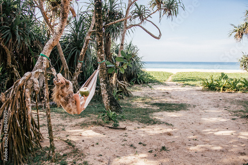 Blond girl relaxing in a hammock on the beach