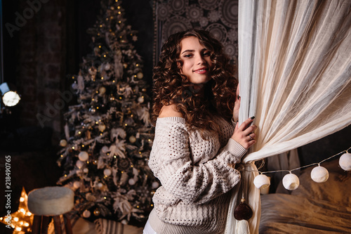 Pretty young woman in a room with christmas decoration. Winter mood, cozy home, scandinavian style