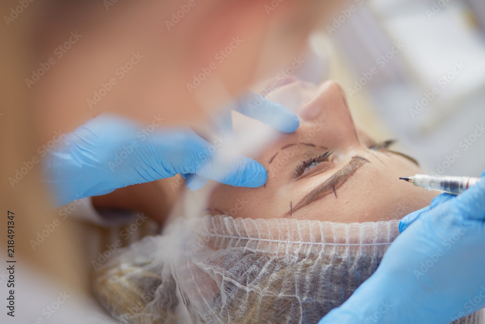 Permanent makeup for eyebrows. Closeup of beautiful woman with thick brows in beauty salon. Permanent makeup for eyebrows. Closeup of beautiful woman with thick brows in beauty salon.