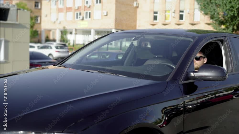 Shot of a businessman driving a clean, shiny black car. Shot of a businessman driving a clean, shiny black car.