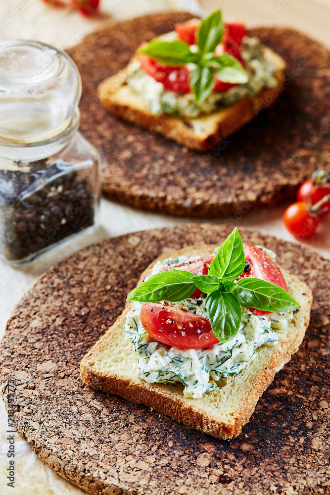 Vegetarian breakfast of champions. Sandwich with egg paste with dill on toasted bread. Tomatoes cocktail and basil on top. Vegetarian breakfast of champions. Sandwich with egg paste with dill on toasted bread. Tomatoes cocktail and basil on top.