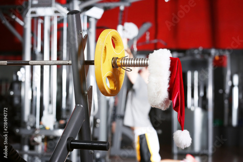 Santa Claus hat on barbell in gym