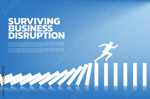 surviving business disruption. Silhouette of businessman running from domino collapse. Concept of business industry disrupt 