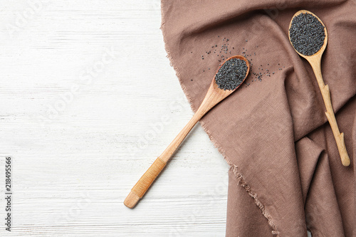 Flat lay composition with poppy seeds on wooden background