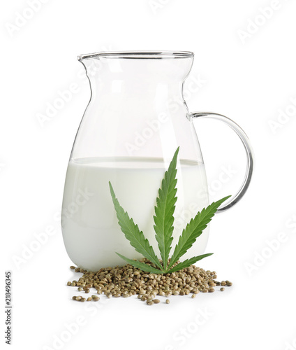 Glass jug with hemp milk on white background