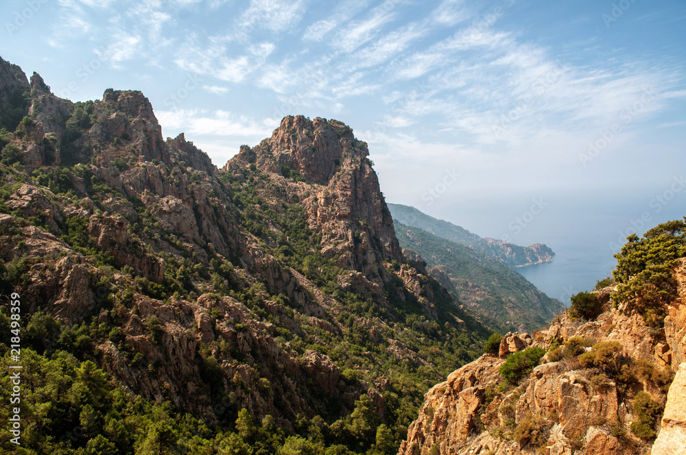 Naklejka premium Evening view of the sun-lit mountains and sea, Corsica (region Calanche)