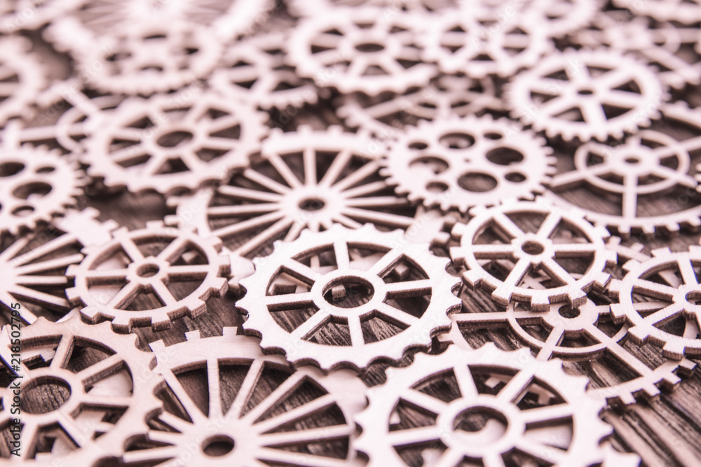 a lot of wooden gears on the background of a wooden table. mechanism, interaction.