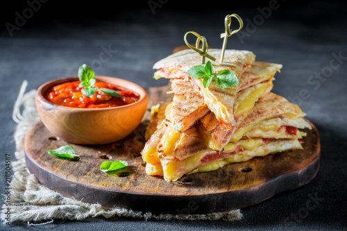 Closeup of tasty quesadilla with sauce and herbs