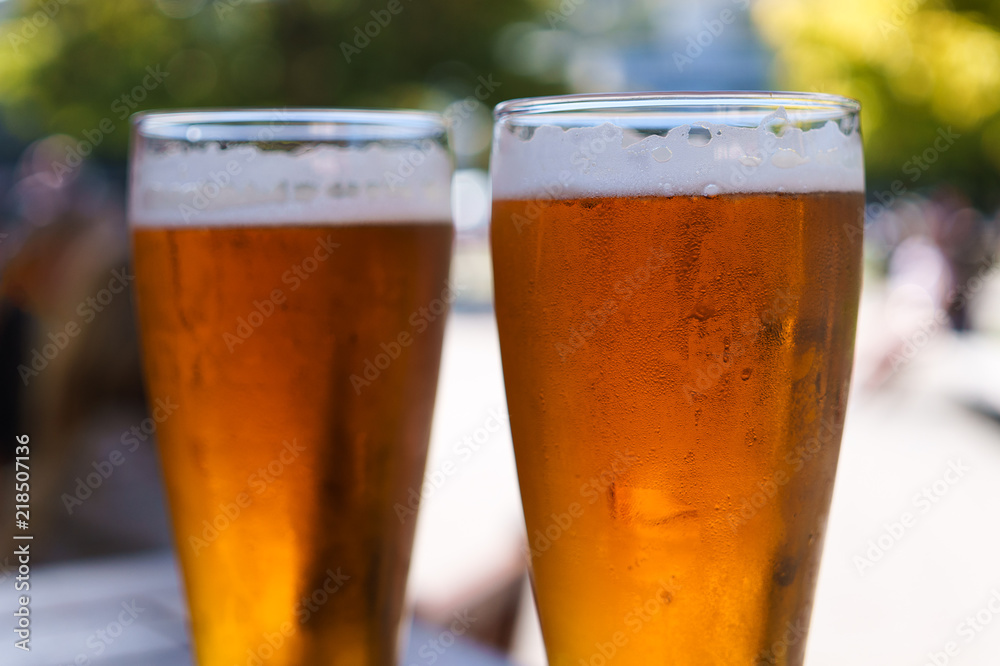 Two full glass of beer with condensation and foam Two full glass of beer with condensation and foam