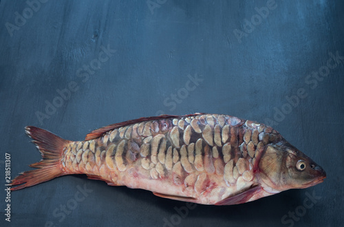 Delicious fresh fish (carp) on dark background for healthy food, diet or cooking concept