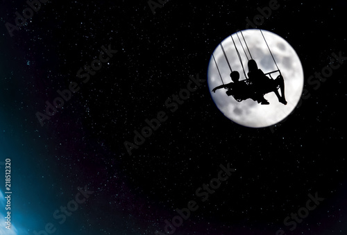 People sitting in a swing in front of the Moon watching the Earth