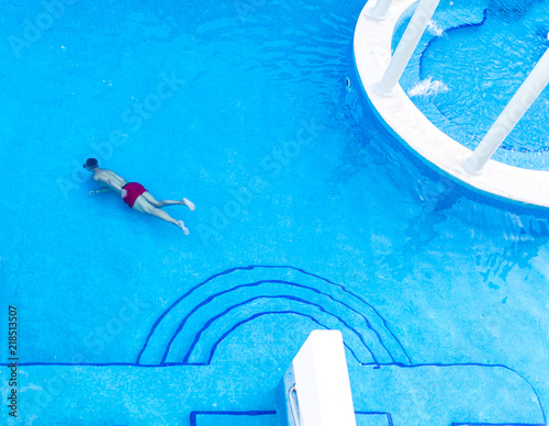 Photography Man submerged or swimming under water in a luxury pool wearing a snorkle and rel