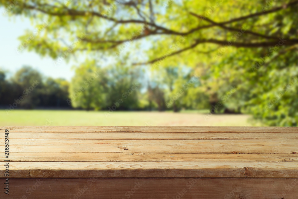 Empty wooden table over autumn nature park background Empty wooden table over autumn nature park background