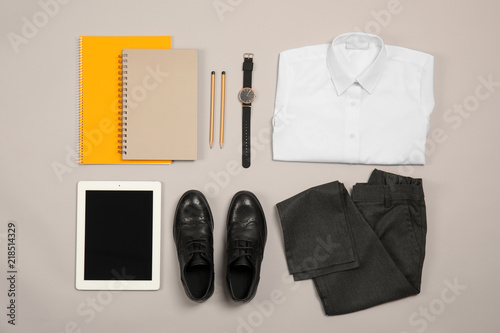 Composition with school uniform for boy and tablet on grey background, top view