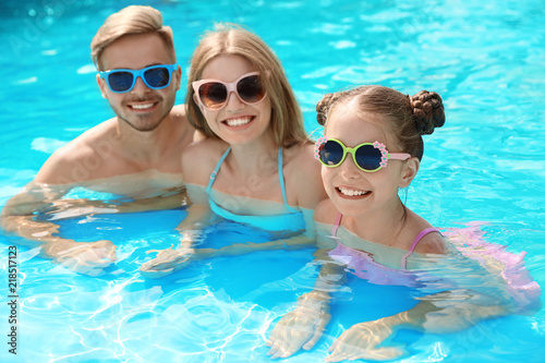 Happy family in pool on sunny day