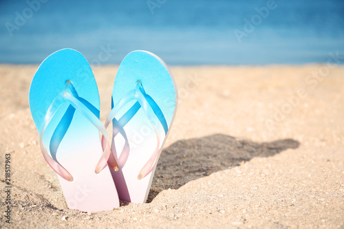 Flip-flops in sand on beach. Space for text
