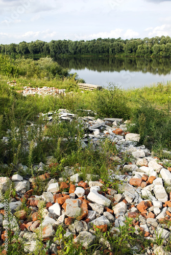 Landfill of building debris on the banks of the river