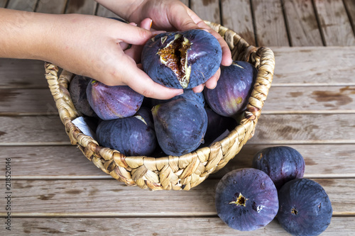 delicious organic figs in a wicker basket on the wooden background