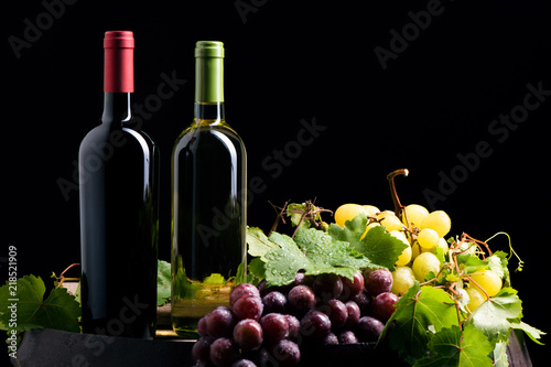 Two bottles of wine on dark background