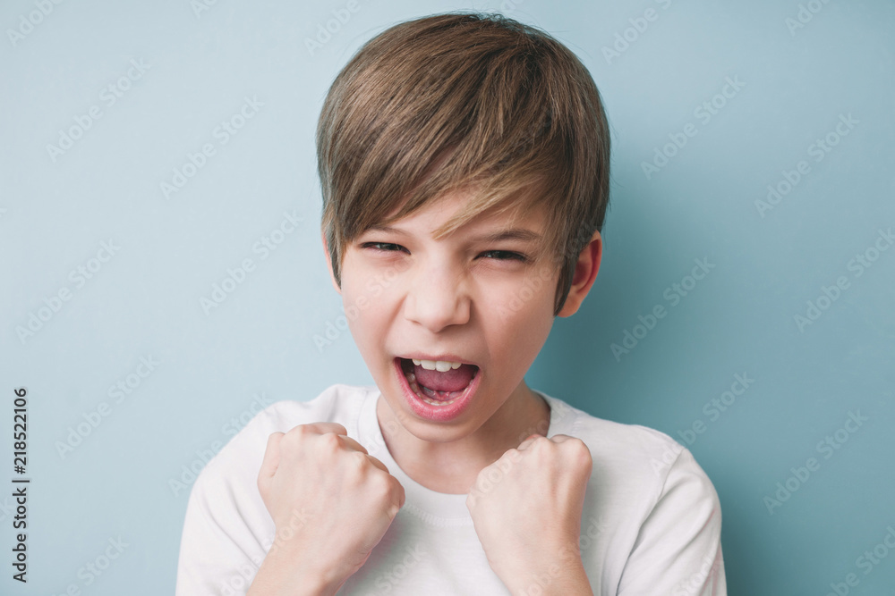 Boy screams and demonstrates his fists in victorious gesture