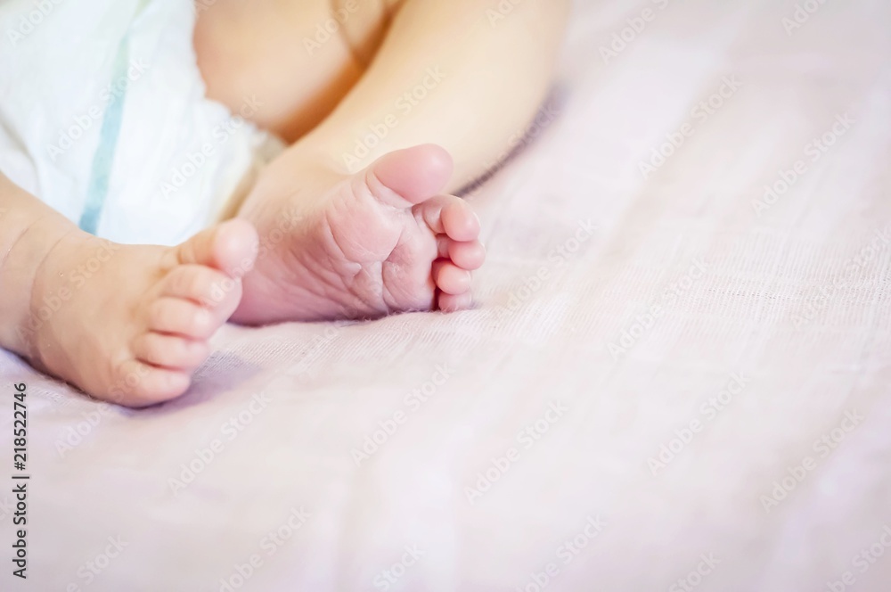 Tiny feet of a newborn baby girl on a gentle pink background. One week year old infant baby. Tiny feet of a newborn baby girl on a gentle pink background. One week year old infant baby.