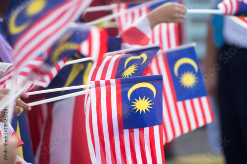 Hand waving Malaysia flag also known as Jalur Gemilang in conjunction with the Independence Day celebration or Merdeka Day. photo