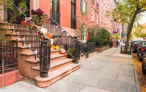 Tablou pe pânză Pumpkins, flowers, and Halloween decorations on steps in West Village, New York