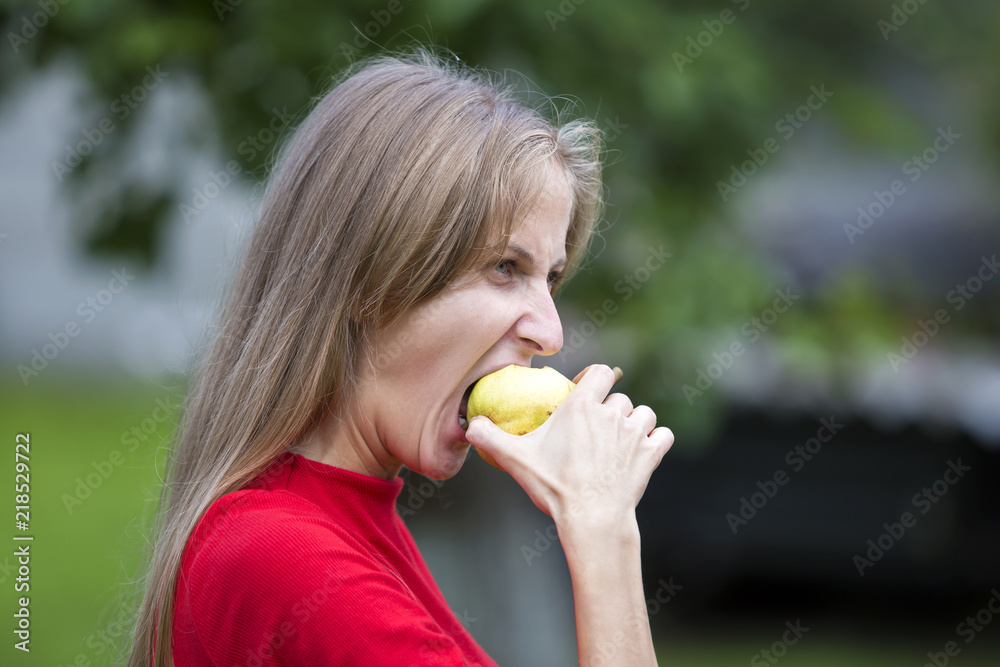 Profile portrait of moody upset angry young woman biting apple. Hard times and problems concept. Profile portrait of moody upset angry young woman biting apple. Hard times and problems concept.