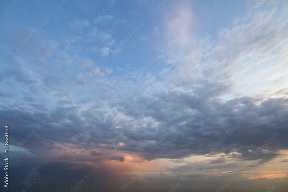 Panorama of sky at sunrise or sunset. Beautiful view of dark blue clouds lit by bright orange yellow sun on clear sky. Beauty and power of nature, meteorology and climate changing concept.