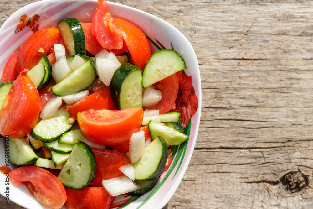 Fresh vegetable salad with tomatoes, cucumbers, onion and olive oil on wooden table. Top view Fresh vegetable salad with tomatoes, cucumbers, onion and olive oil on wooden table. Top view