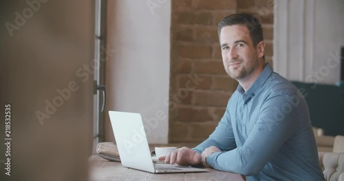 young man working in cafe planning new business, typing and drinking morning coffee, then looking at camera. business concept 4k