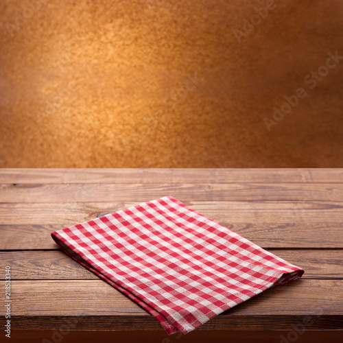 Red checkered tablecloth on wooden table. Napkin close up top view mock up