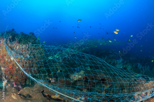 Photography A huge abandoned ghost fishing net entangled over a large part of a tropical cor